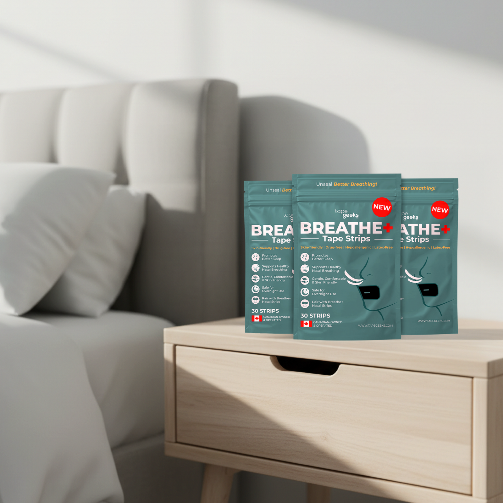 Three packages of Tapegeeks Breathe+ mouth tape strips, on a side table next to a bed