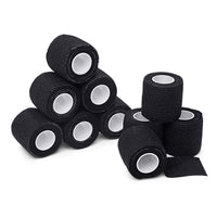 Several black TapeGeeks cohesive bandage rolls displayed together, emphasizing the strong yet gentle compression wrap that sticks to itself without adhesives.