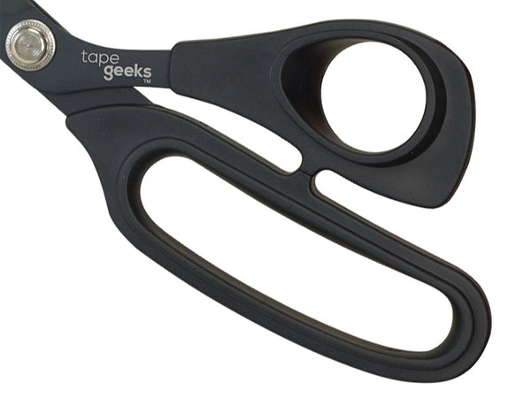 Close-up of the ergonomic, rubber-coated handles on TapeGeeks kinesiology scissors, showing the non-slip grip that improves comfort and control during cutting.